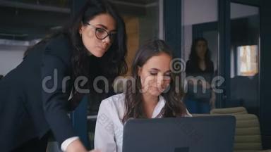 女组长对一名在办公室<strong>使用</strong>计算机的<strong>员工</strong>的项目进行修正。 两个自信的办公室
