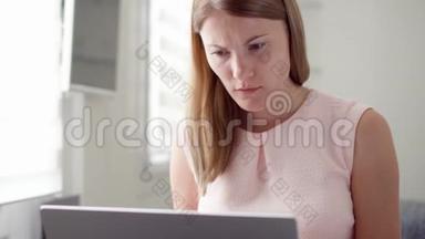 年轻女子在她的笔记本电脑屏幕上收到非常坏的消息，对失败感到沮丧和沮丧