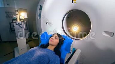 年轻女孩在一家现代医院的磁共振成像MRI扫描仪上。