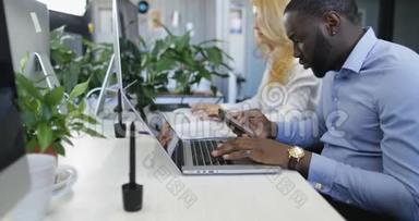 开放的商务办公室，忙碌的工作人员在电脑上打字，商务人士小组混合种族小组在现代工作