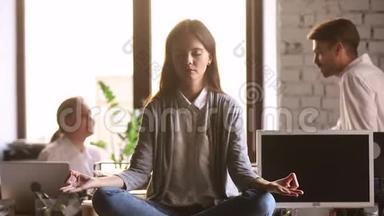 当同事争吵时，坐在办公桌前的女人专注于冥想