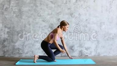 适合运动的女人在瑜伽垫上做木板。