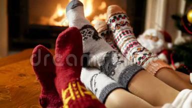 在燃烧的壁炉旁的客厅里，三双脚穿着温暖的羊毛袜，拍摄了4k镜头