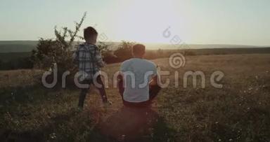爸爸和儿子在大自然中度过了一段变态的时光，爸爸坐在草地上，小男孩来自