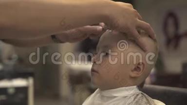 理发师用剃须刀做男式沙龙发型。 儿童发型概念。 理发师用直剃须刀