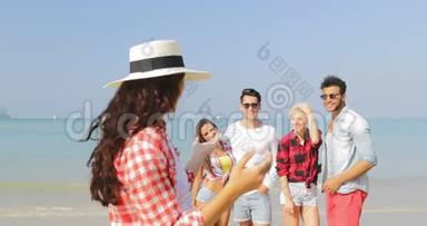 在沙滩上拍照的女孩手机上拍照的人快乐的男人和女人度假的游客