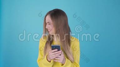 年轻漂亮的女人用智能手机在孤立的背景下发送<strong>信息</strong>，吓得满脸惊讶