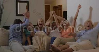 家庭在电视上观看体育赛事，对胜利感到高兴