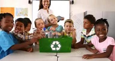 在教室里，孩子们把垃圾桶放在回收箱里