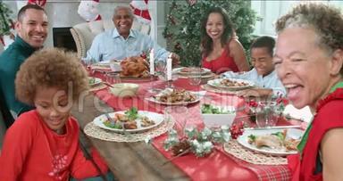 带着祖父母坐在餐桌旁享受圣诞<strong>大餐</strong>的家庭慢动作顺序-看着镜头