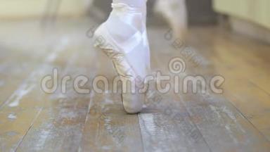 芭蕾。 在芭蕾训练中，一个穿白色芭蕾舞鞋的女孩`了她的腿。 古典舞的元素。 4K