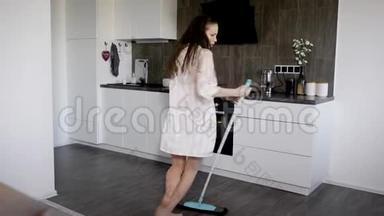 科摩罗妇女在假日打扫她家的厨房时，用拖把跳舞，唱歌，跳舞，滑稽