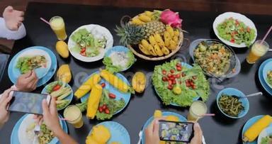 以手机智能手机顶部视角拍摄健康素食照片的人组、坐着吃饭的朋友