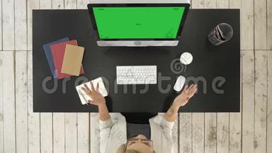 在电脑上做视频会议的人。 绿色屏幕模拟显示。