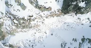空中俯视冬季雪山岩石。 落基山脉覆盖着冰雪冰川。 冬天