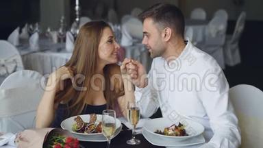幸福的恋人是在餐厅的浪漫晚餐中牵手、交谈和亲吻。 感情