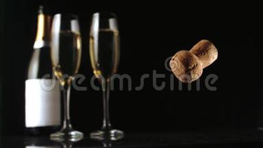 香槟软木塞落在两个玻璃长笛和瓶子前面