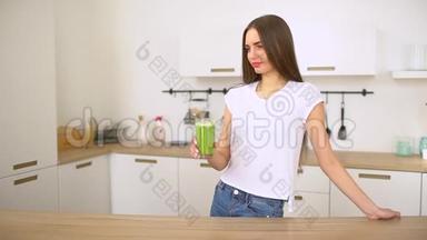绿色排毒冰沙-健康的女人喝蔬菜冰沙。 快乐的年轻人喝着新鲜的绿色果汁