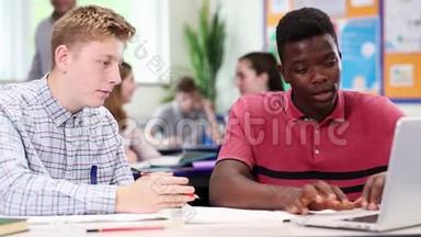 两名男高中生在教室里做手提电脑的老师