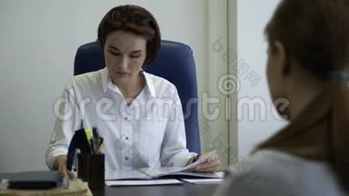 两个女商人一起在办公室读<strong>报告</strong>。 女上司检查女雇员<strong>报告</strong>