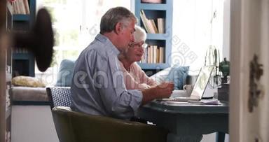 在家庭办公室看笔记本电脑时担心的老夫妻