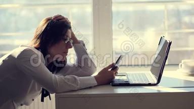 一位年轻的女职员办公室工作人员在上班的一间办公室里用<strong>手机浏览</strong>社交网络。 一小段