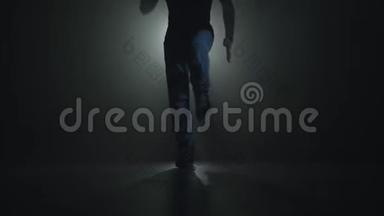 一位才华横溢的年轻舞者在聚光灯前的舞台上跳嘻哈街舞的特写剪影