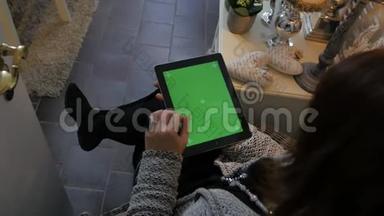 女士<strong>坐在地板上</strong>，使用绿色屏幕<strong>的</strong>立式平板电脑。 <strong>女人</strong>用垫子`双手合拍