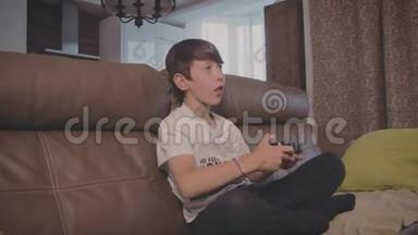 男孩在游戏<strong>机上</strong>玩电子游戏在家里的沙发上