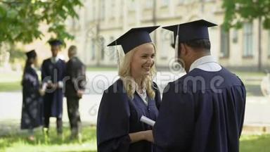 男、女毕业生在仪式后交谈，大学教育，成人生活