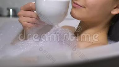 漂亮的年轻女士在浴缸里喝热<strong>咖啡</strong>，享受休闲<strong>时光</strong>，放松身心