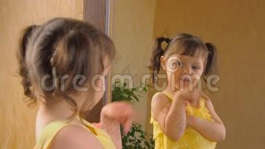 小女孩在照镜子。 一个头上有尾巴的漂亮女孩正在<strong>眨眼</strong>睛。 一个孩子