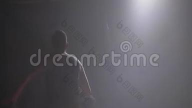 两个篮球运动员的影子在室内一对一玩，室内有烟雾和<strong>泛光灯</strong>