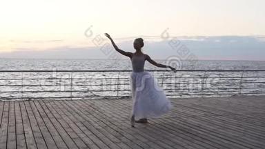 年轻漂亮的芭蕾舞演员穿着<strong>白色</strong>的芭蕾舞裙，在她的尖角芭蕾<strong>舞鞋</strong>上优雅地跳舞。 跳跃，表演