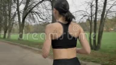 夏天，年轻的运动女孩带着耳机在公园里跑步，健康的生活方式，运动理念，相机圆步