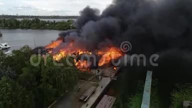 大火燃烧后工业仓库中心大楼的空中景观，屋顶浓烟滚滚