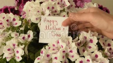 女人`手拿着一张贺卡，用美丽`花束送给母亲