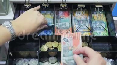 一位店员从收银机中取出澳大利亚货币的高视角
