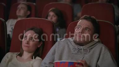 年轻夫妇在电影院看恐怖电影。 把爆米<strong>花洒</strong>了