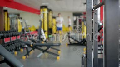 使用<strong>运动器材</strong>在健身俱乐部健身房锻炼的离焦人群
