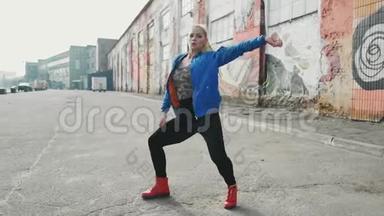 金发女子舞蹈<strong>表演</strong>现代街舞摆姿势，自由式<strong>街头</strong>，都市。 4K股录像
