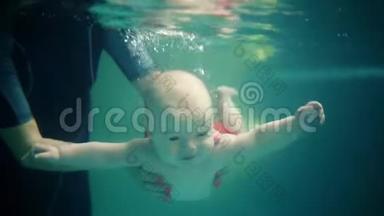 可爱的男孩在<strong>游泳</strong>池里<strong>学习</strong>水下<strong>游泳</strong>。婴儿用张开的眼睛在水下<strong>游泳</strong>。健康的家庭生活方式