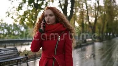 秋<strong>日</strong>散步时，一位年轻的美女在黄、红叶背景下用<strong>手机</strong>聊天