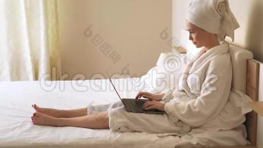 女人在床上用笔记本电脑打字。