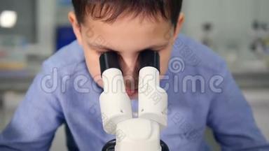 学校的孩子在化学教室里看显微镜做科学<strong>实验</strong>。