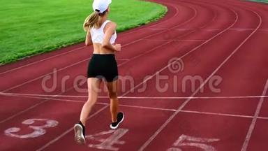 运动的女人跑在<strong>跑道</strong>上。 体育女孩在<strong>体育场</strong>慢跑