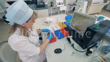 一名实验室工作人员移动血液样本，在现代实验室进<strong>行医</strong>学测试。