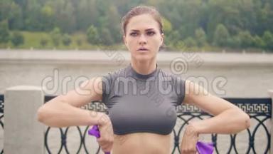 运动女子在夏季公园用健身拓展器做健身运动