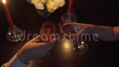 手中的男人和女人，他们用香槟碰杯。 情人节。 求婚。