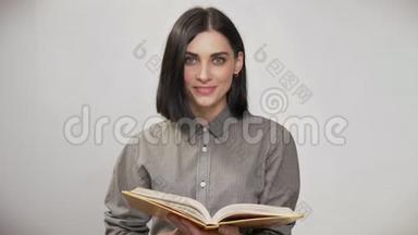 年轻漂亮的女人，<strong>棕色短发</strong>，拿着书看书，然后看着相机，微笑着，白色的背景